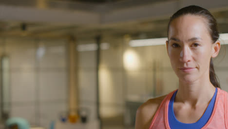 Mid-Shot-of-a-Young-Woman-Looking-at-Camera-in-Gym